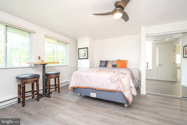 bedroom with a textured ceiling, baseboards, and wood finished floors