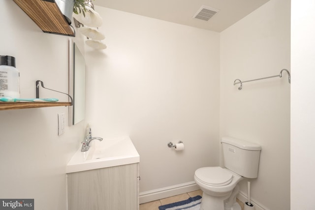 bathroom featuring visible vents, toilet, tile patterned flooring, baseboards, and vanity