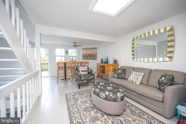 tiled living room with a ceiling fan