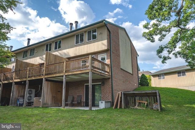 back of property featuring brick siding, a patio area, and a lawn