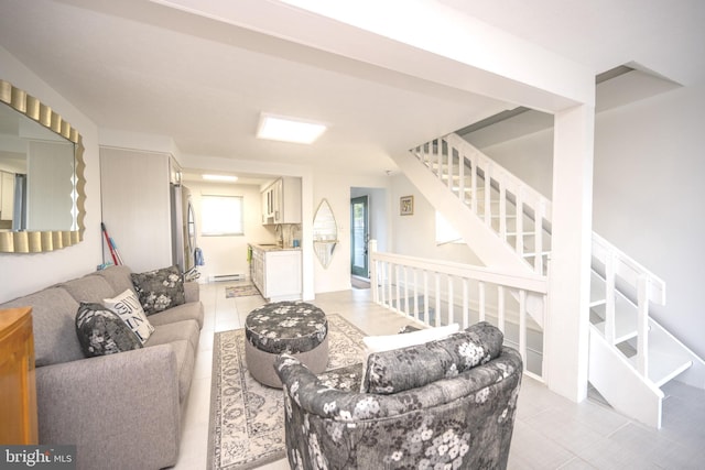 living room featuring stairs, light tile patterned flooring, and baseboard heating