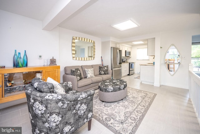 living area with plenty of natural light, beamed ceiling, and baseboards