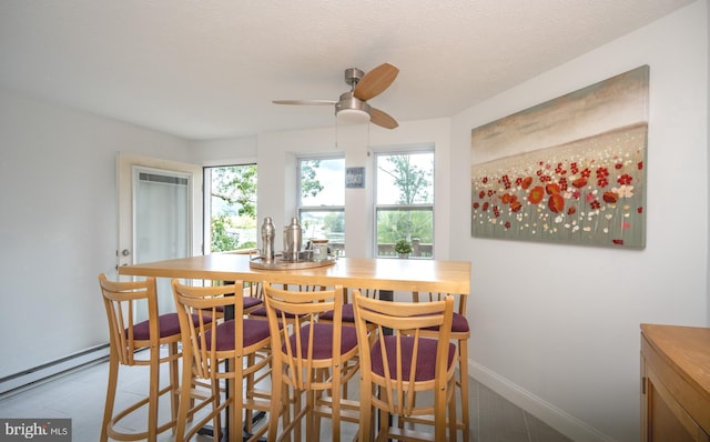 dining area featuring ceiling fan, baseboards, baseboard heating, and a textured ceiling