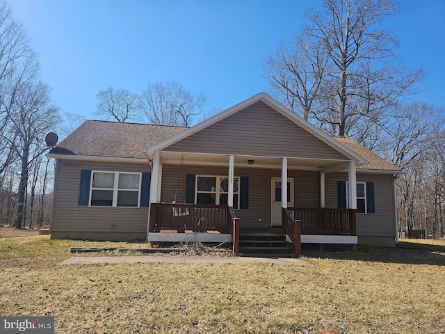 view of front facade featuring covered porch, a shingled roof, and a front yard