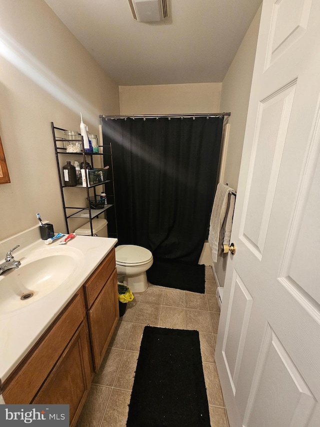 bathroom with vanity, a shower with shower curtain, visible vents, tile patterned flooring, and toilet