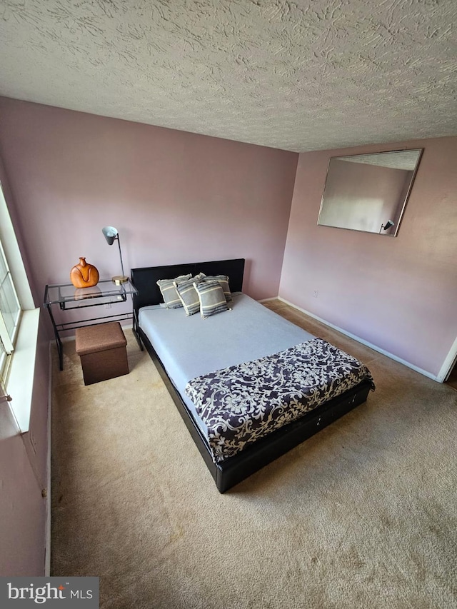 bedroom featuring carpet flooring, a textured ceiling, and baseboards