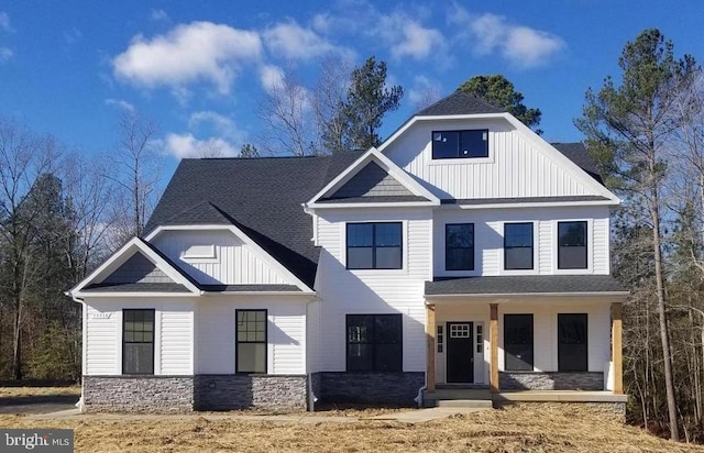 modern inspired farmhouse featuring covered porch, board and batten siding, and roof with shingles