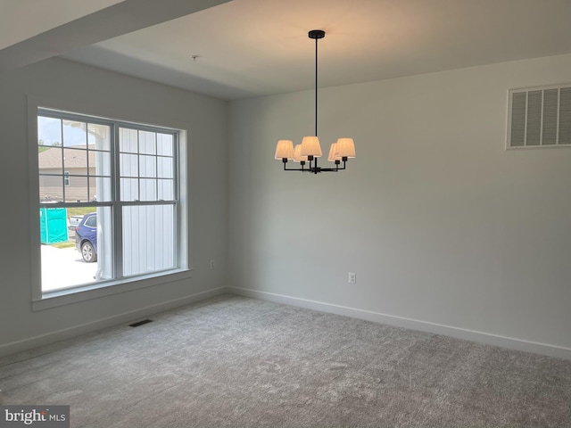 spare room with a notable chandelier, carpet, visible vents, and baseboards