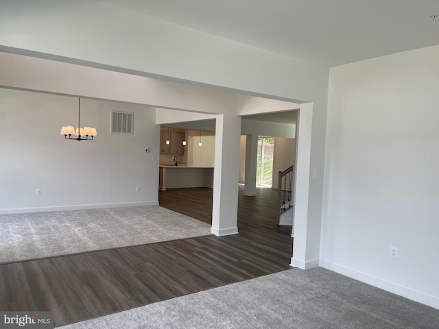 spare room with visible vents, baseboards, stairs, wood finished floors, and a notable chandelier