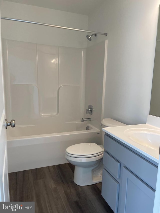 bathroom with shower / bathtub combination, toilet, vanity, and wood finished floors