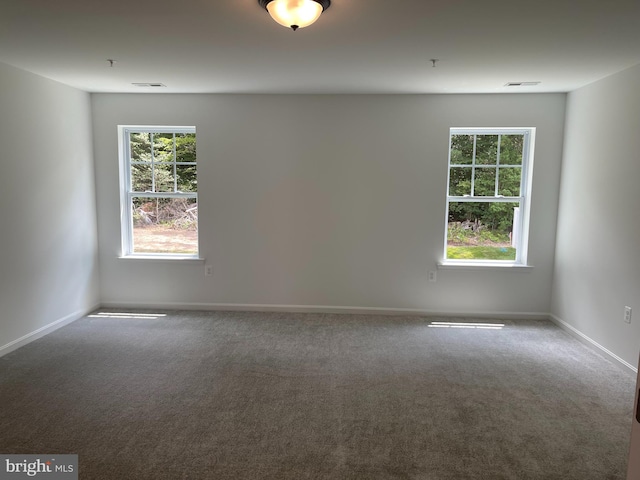 spare room featuring visible vents, baseboards, and carpet floors