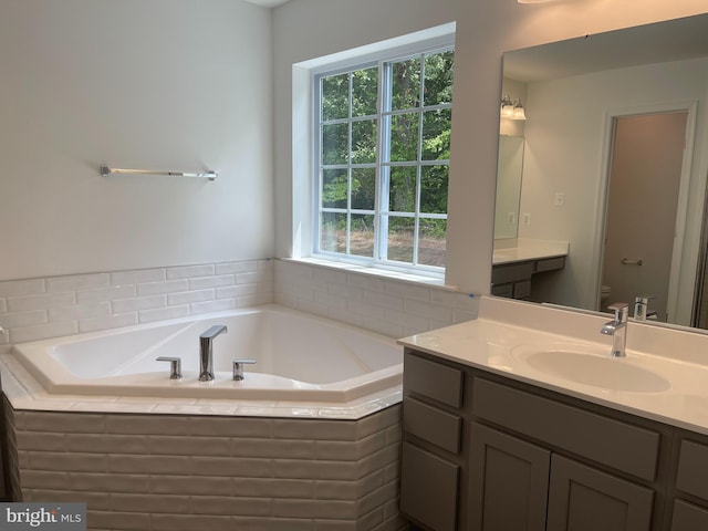 bathroom featuring vanity, toilet, and a bath