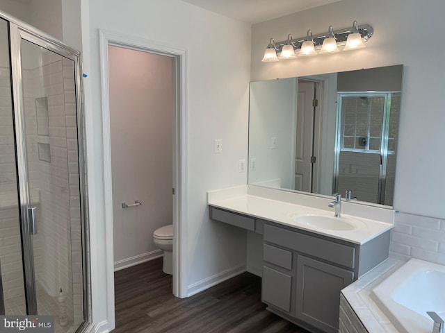 full bathroom with wood finished floors, baseboards, a shower stall, tiled bath, and toilet