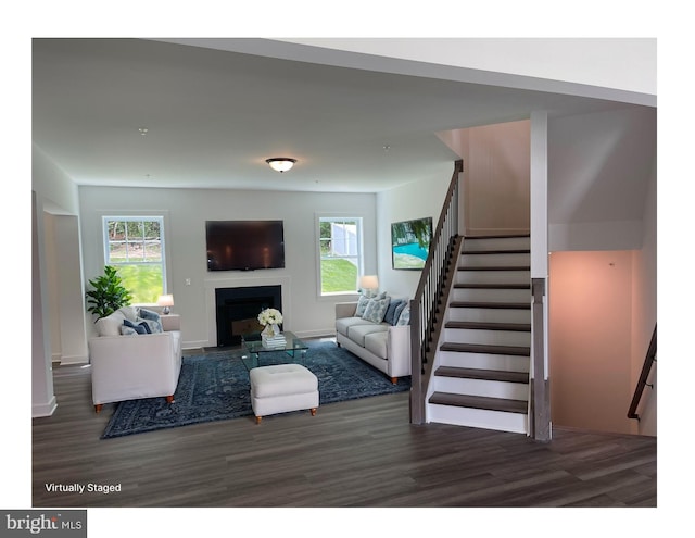 living room with a fireplace, a healthy amount of sunlight, wood finished floors, and stairs