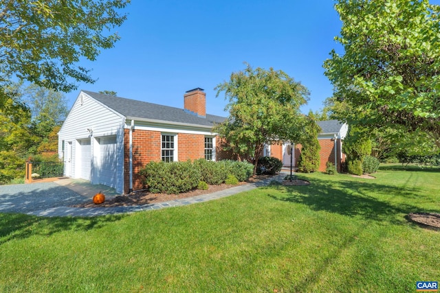 view of front of home with a front lawn, a garage, brick siding, and a chimney