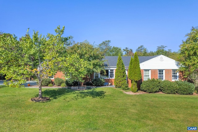 exterior space with brick siding and a front lawn