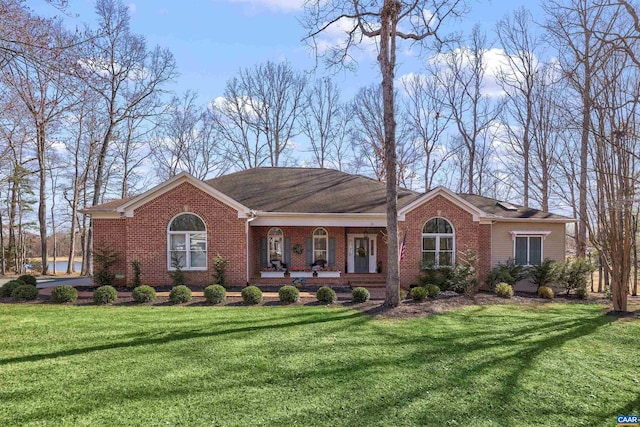 ranch-style home featuring brick siding, a porch, and a front lawn