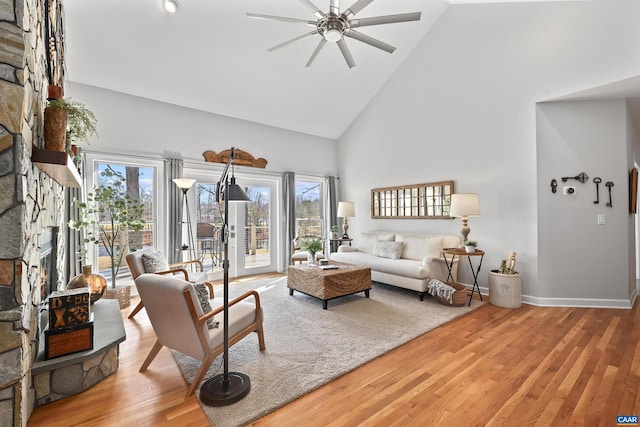 living room featuring a wealth of natural light, high vaulted ceiling, ceiling fan, and wood finished floors