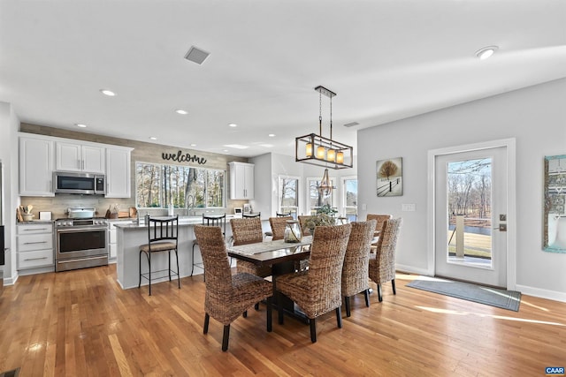 dining room with recessed lighting, visible vents, light wood finished floors, and baseboards