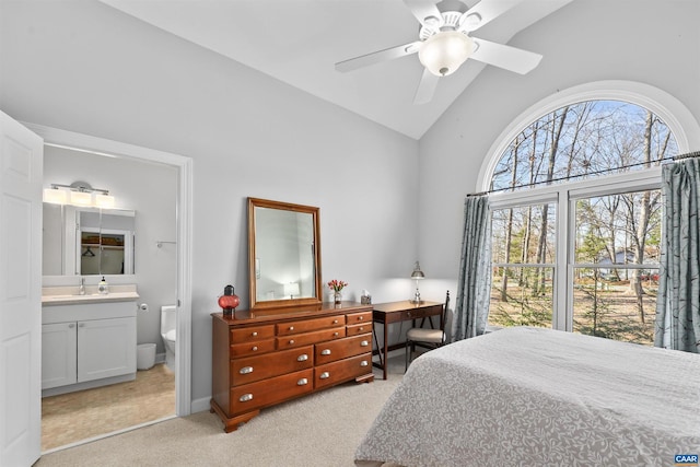 bedroom featuring connected bathroom, light carpet, high vaulted ceiling, a ceiling fan, and a sink