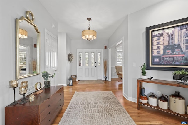 foyer featuring baseboards and wood finished floors