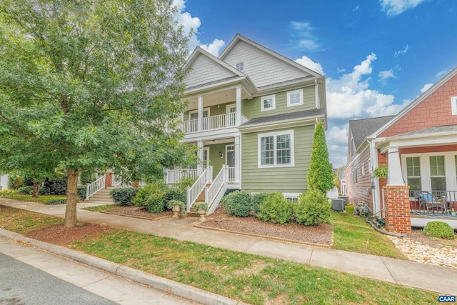 view of front of house with a balcony, a porch, and central AC