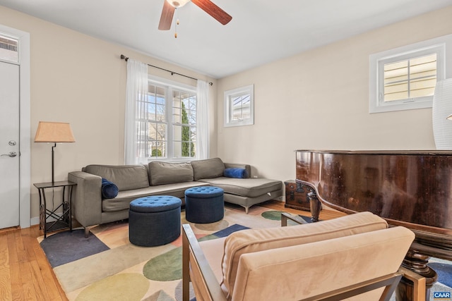 living area with wood finished floors and a ceiling fan