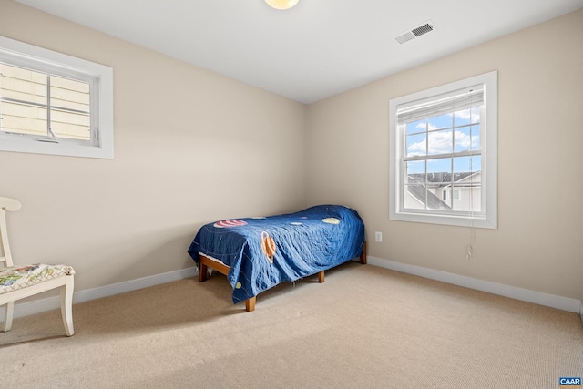 carpeted bedroom featuring visible vents and baseboards