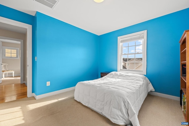 bedroom featuring visible vents, multiple windows, carpet flooring, and baseboards