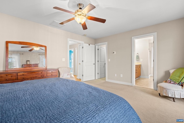 bedroom with visible vents, connected bathroom, baseboards, ceiling fan, and light colored carpet