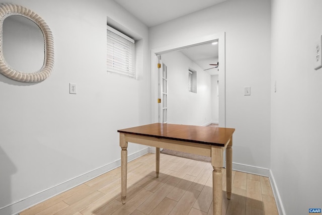 hallway with light wood-type flooring and baseboards