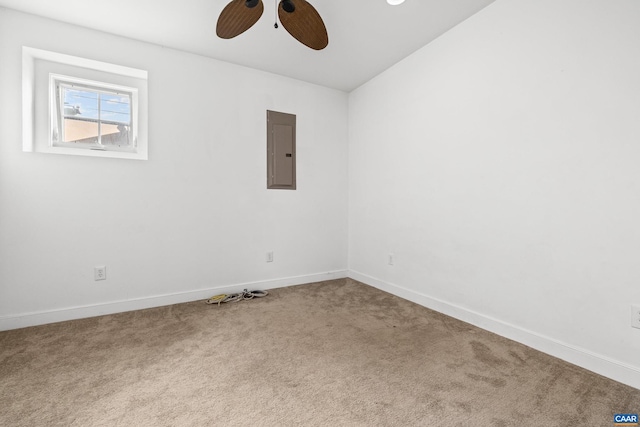 carpeted spare room featuring electric panel, baseboards, and ceiling fan