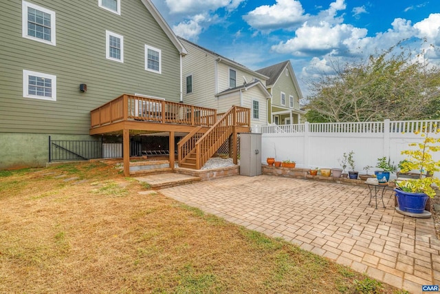 back of property featuring stairway, fence private yard, a wooden deck, a lawn, and a patio area