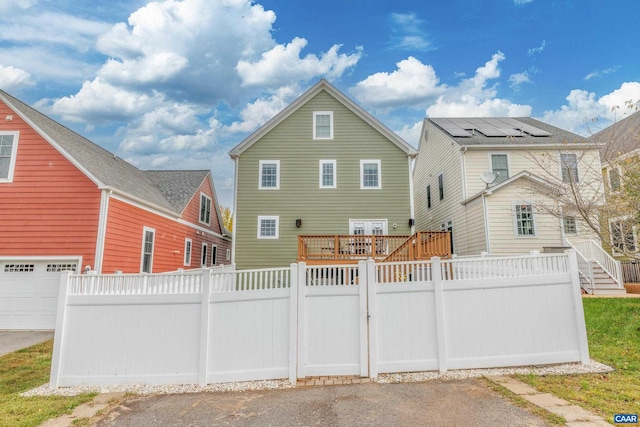 rear view of house with a garage and fence