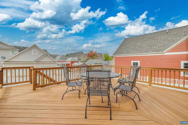 deck with outdoor dining area and a residential view