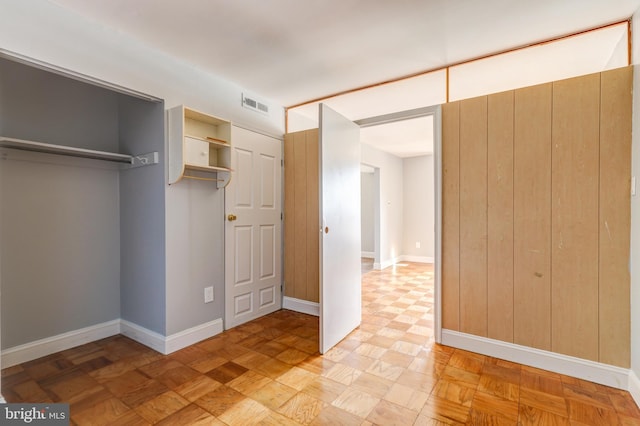 unfurnished bedroom featuring visible vents, baseboards, and a closet