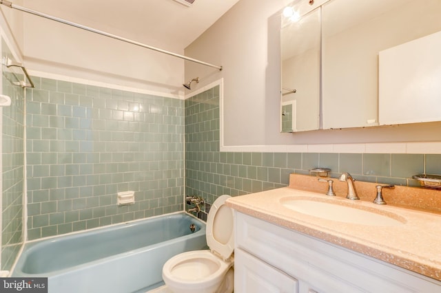 full bathroom featuring vanity,  shower combination, toilet, and tile walls