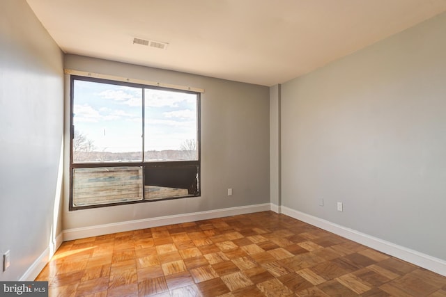 empty room with visible vents and baseboards