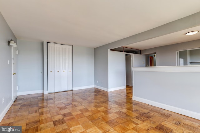 unfurnished room with baseboards