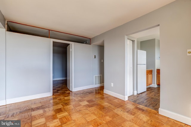 spare room featuring baseboards and visible vents