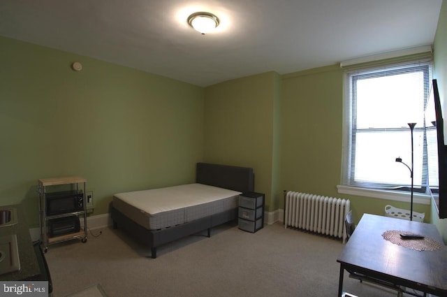 bedroom with radiator heating unit, carpet, and baseboards