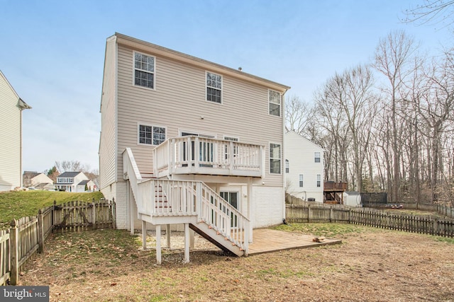 back of property featuring a wooden deck, brick siding, a fenced backyard, and stairway