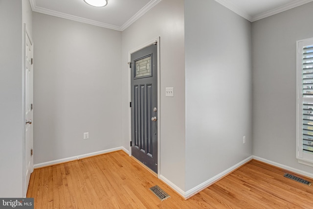 foyer entrance with crown molding, visible vents, and light wood-type flooring