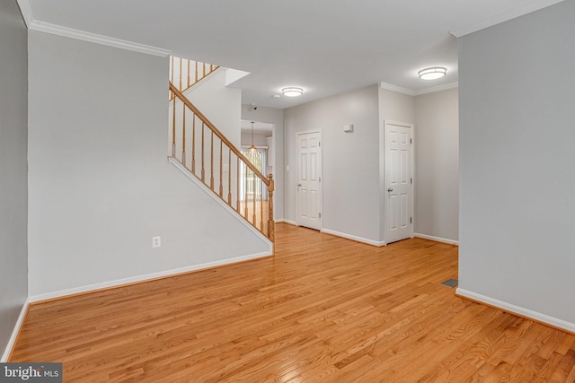 interior space with ornamental molding, stairs, baseboards, and wood finished floors