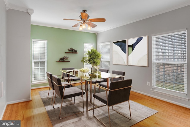 dining room with crown molding, wood finished floors, and baseboards