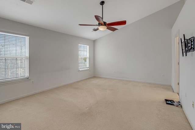 spare room with baseboards, light colored carpet, a ceiling fan, and lofted ceiling