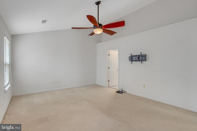 empty room featuring a ceiling fan, carpet, visible vents, baseboards, and vaulted ceiling