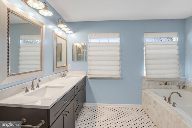 full bathroom with a bath, double vanity, baseboards, and a sink