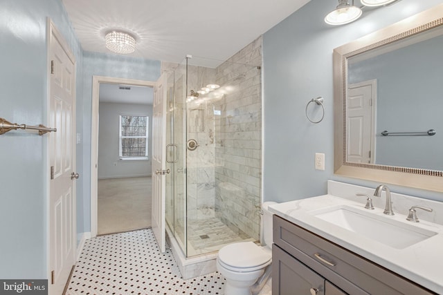 full bathroom with vanity, a shower stall, toilet, and visible vents