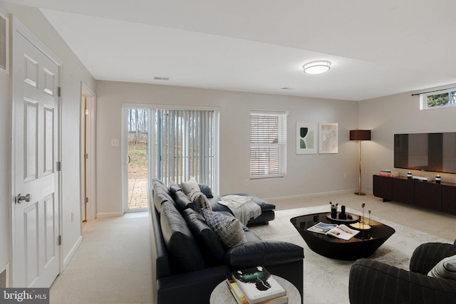 living room featuring visible vents, light carpet, and baseboards